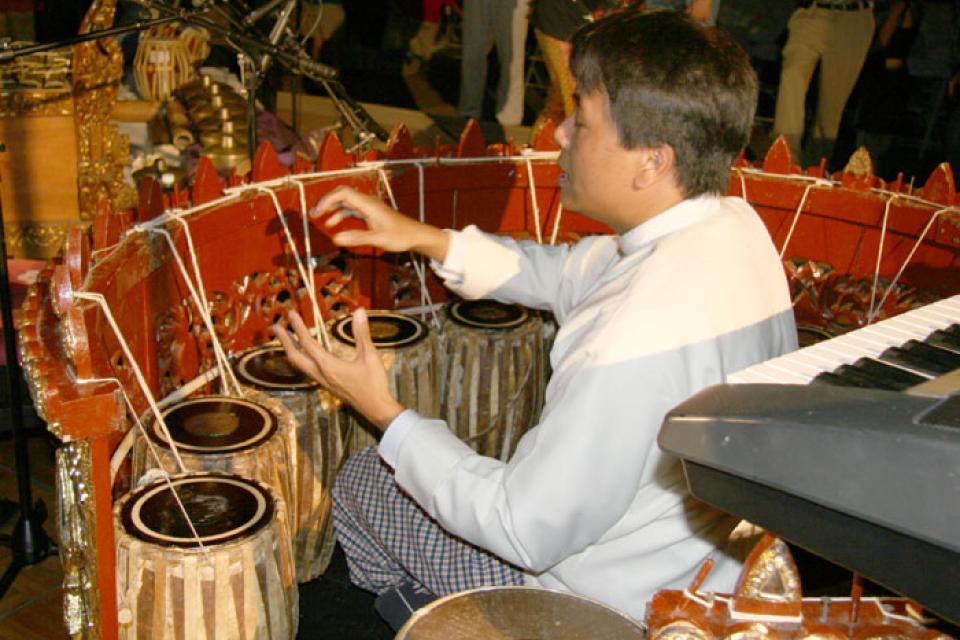 Kyaw Kyaw Naing demonstrates the Burmese circle drum onstage at the First and Central Summer Concert Series